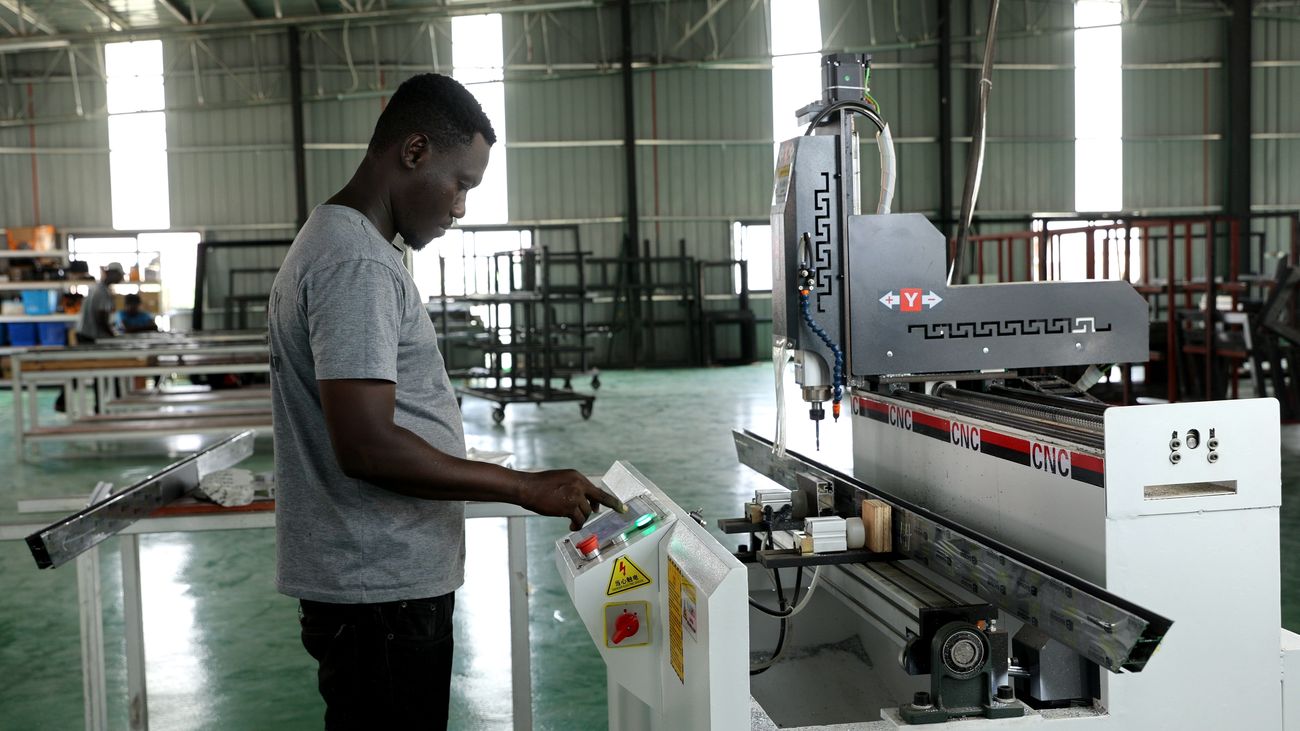 Worker feeding aluminium profile into a machine